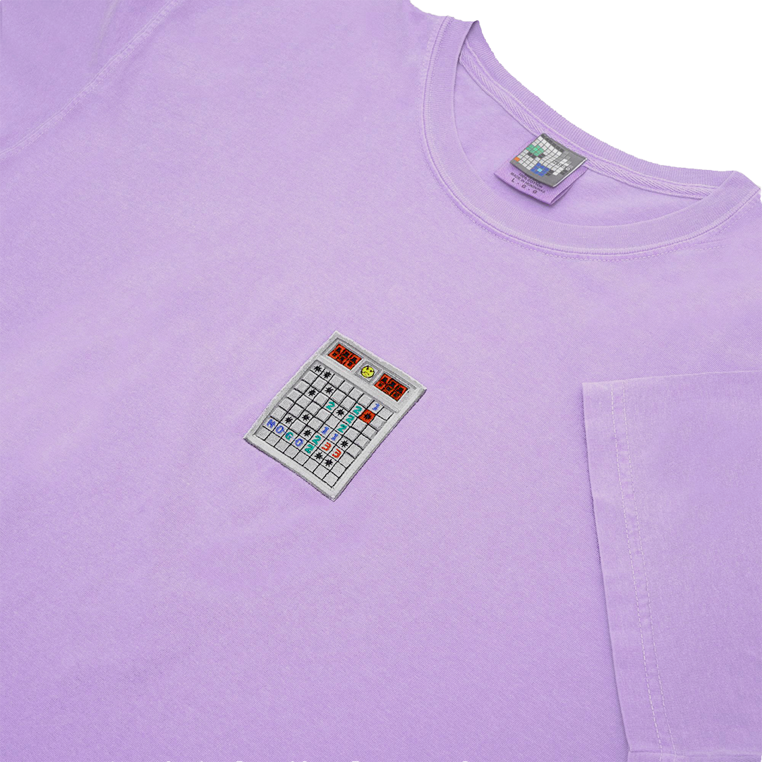 Side-angle photograph of purple tshirt with minesweeper embroidery design