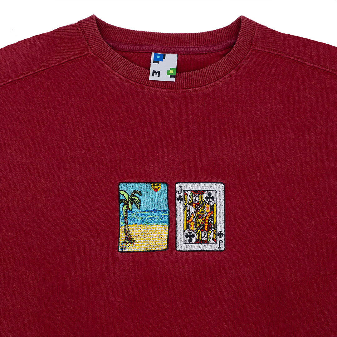 Collar shot photograph of red crewneck with solitaire card embroidery