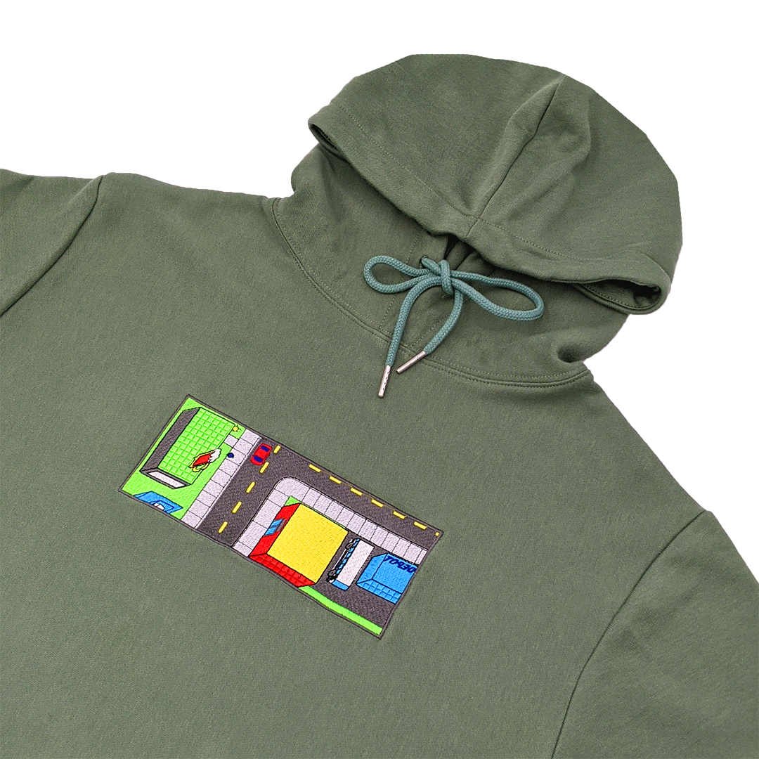 Side-angle photograph of green hoodie with embroidery design