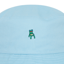 Load image into Gallery viewer, Photograph of a blue bucket hat with an embroidered froggy chair design
