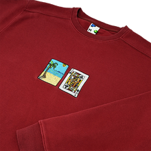 Load image into Gallery viewer, CoSide-angle photograph of red crewneck with solitaire card embroidery
